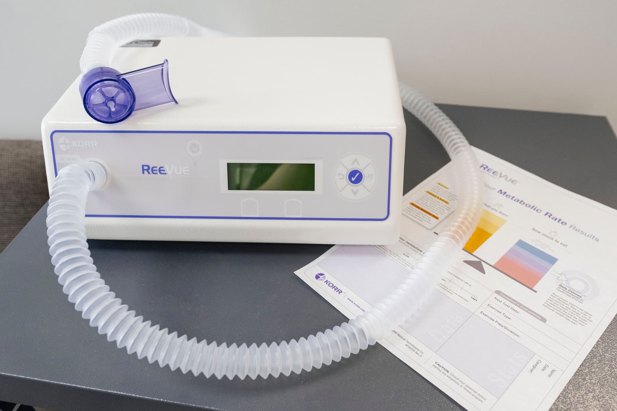 Image of Medical machine with digital display and attached tubing, placed on a desk.
