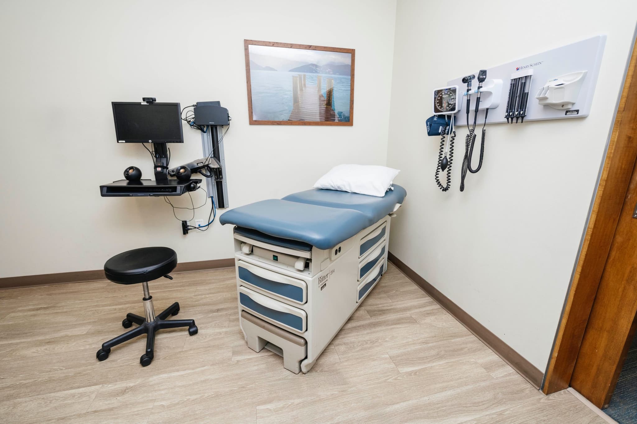 Medical exam room equipped with an exam table, diagnostic tools, and seating for routine checkups and progress evaluations.