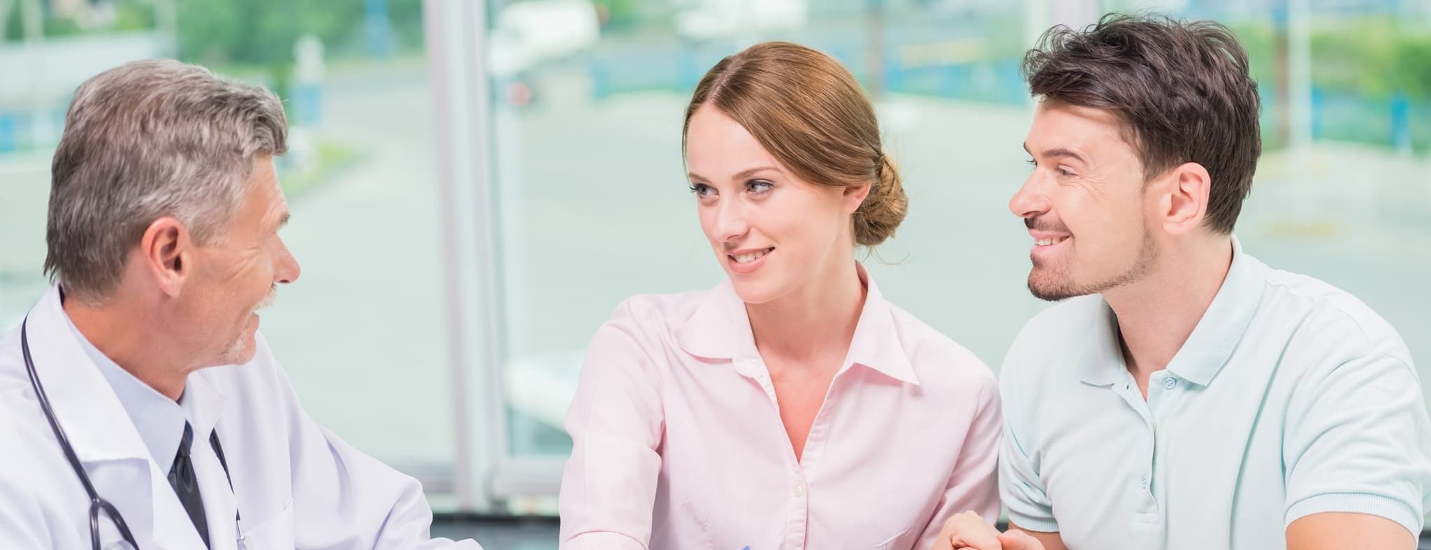 Picture of happy couple talking with doctor