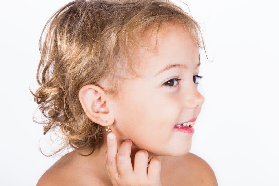 child showing ear piercing