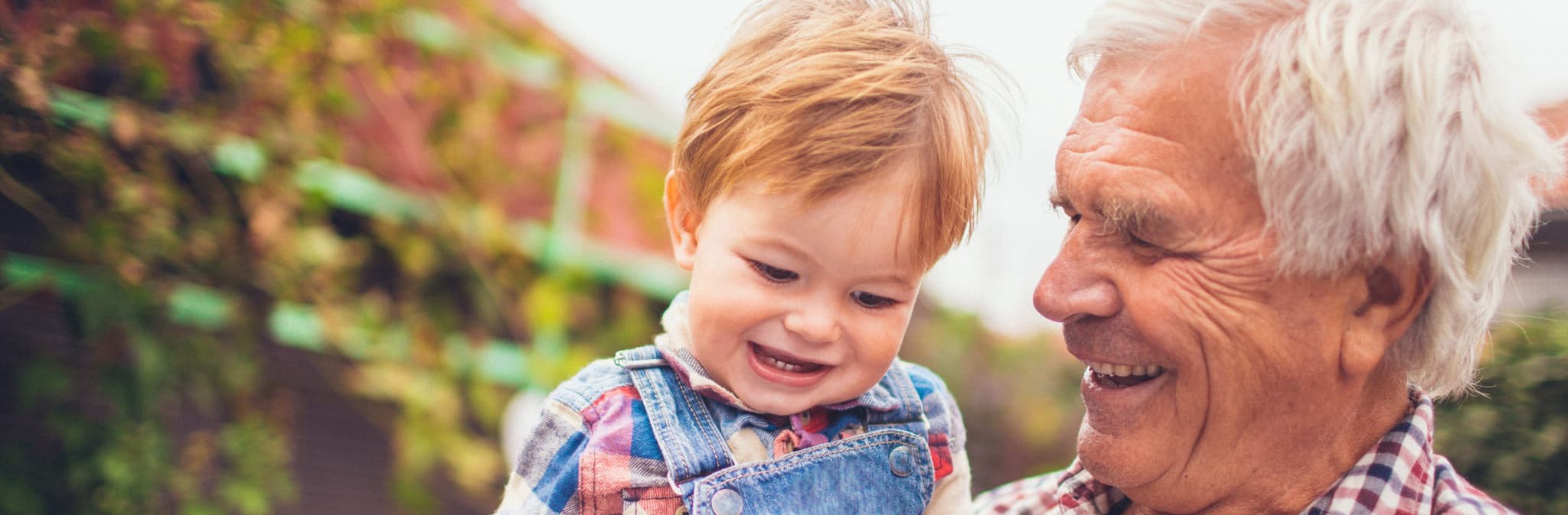 Picture of smiling grandpa holding happy grandchild