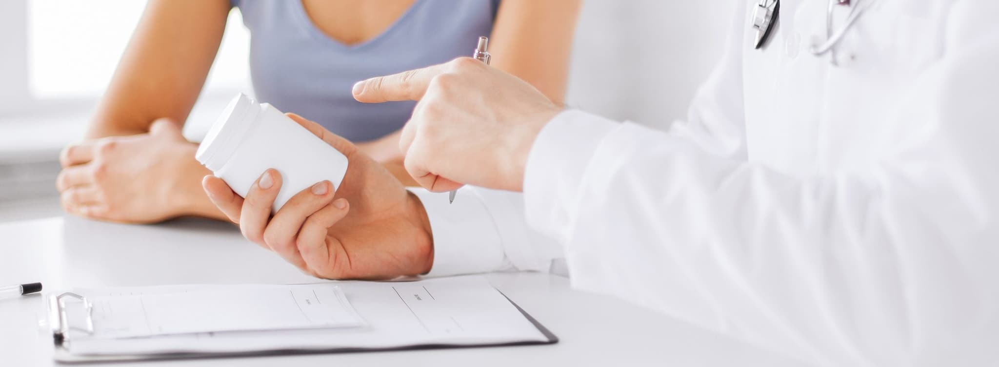 Picture of doctor giving prescription bottle to patient