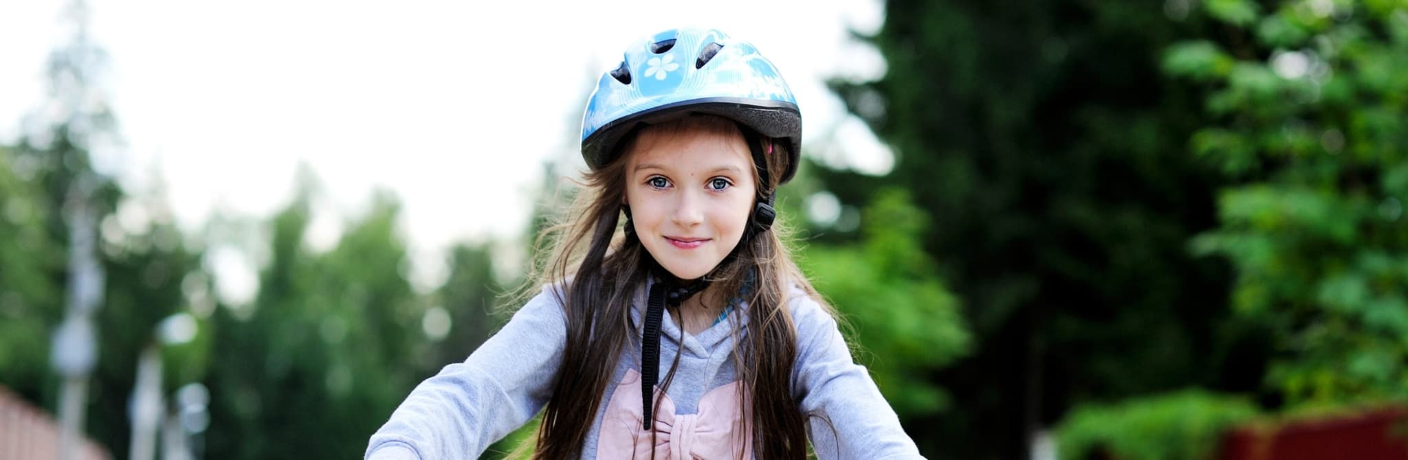 Picture of happy girl riding bike on side walk