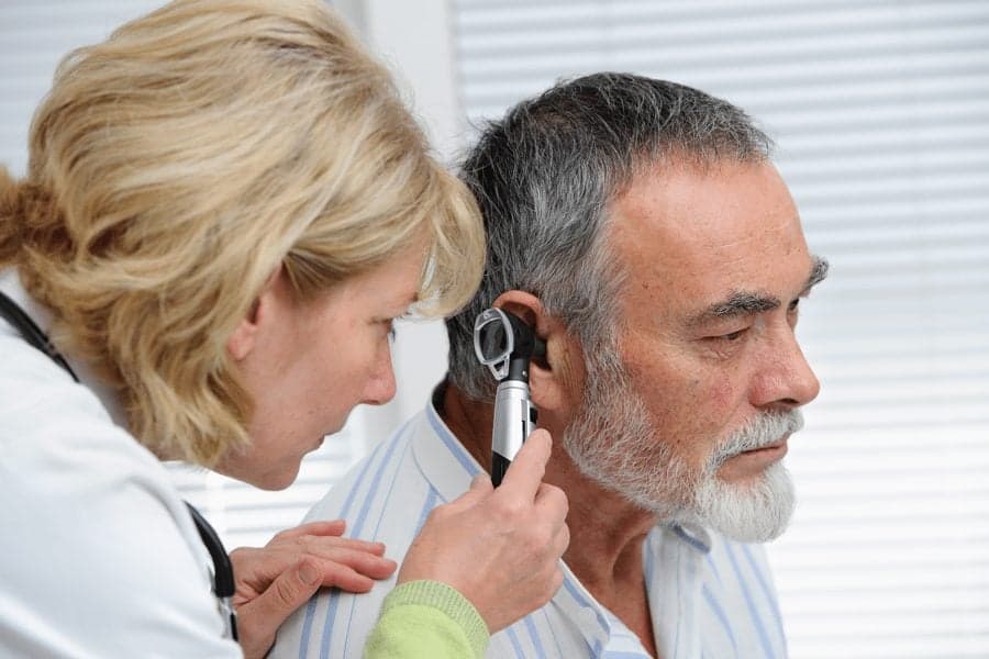 doctor examining mature patient's ear