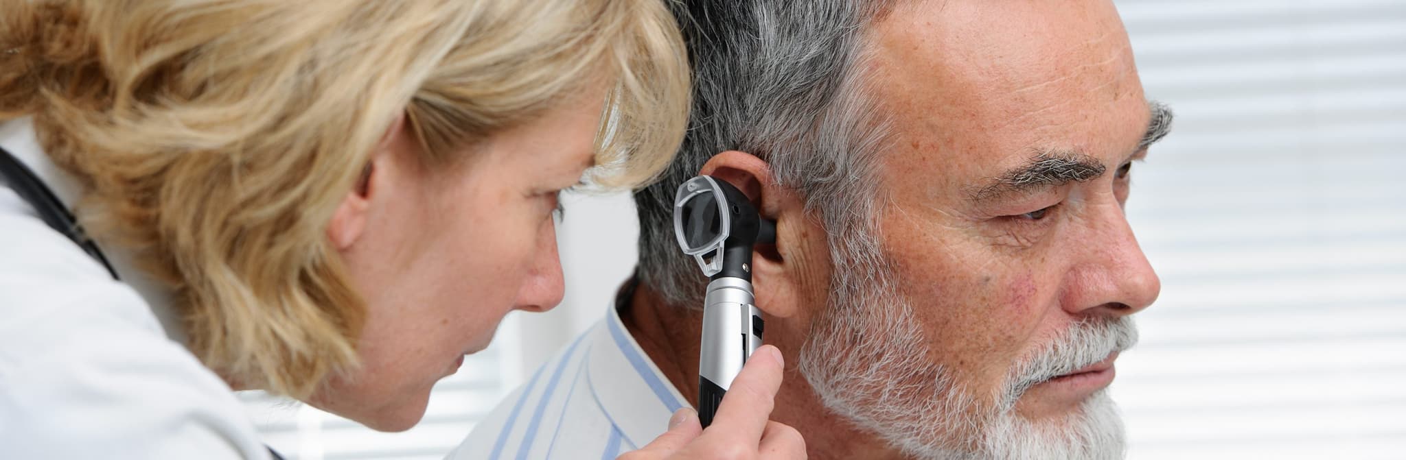 Picture of doctor examining mature patient's ear