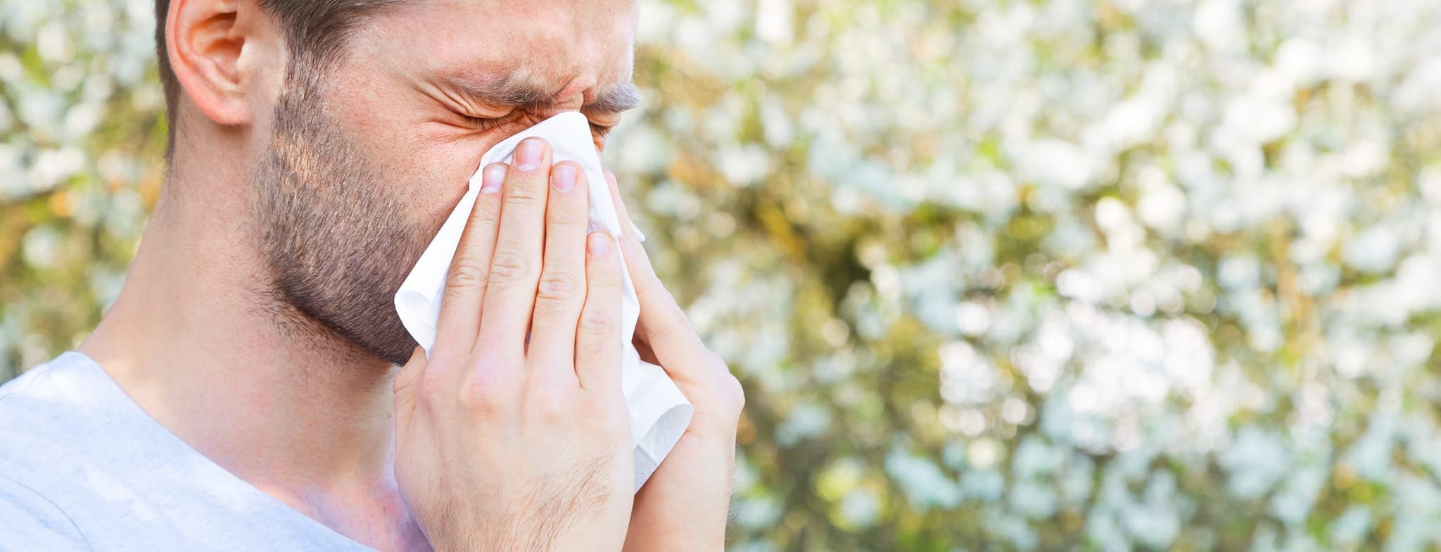 Picture of man blowing his nose outside