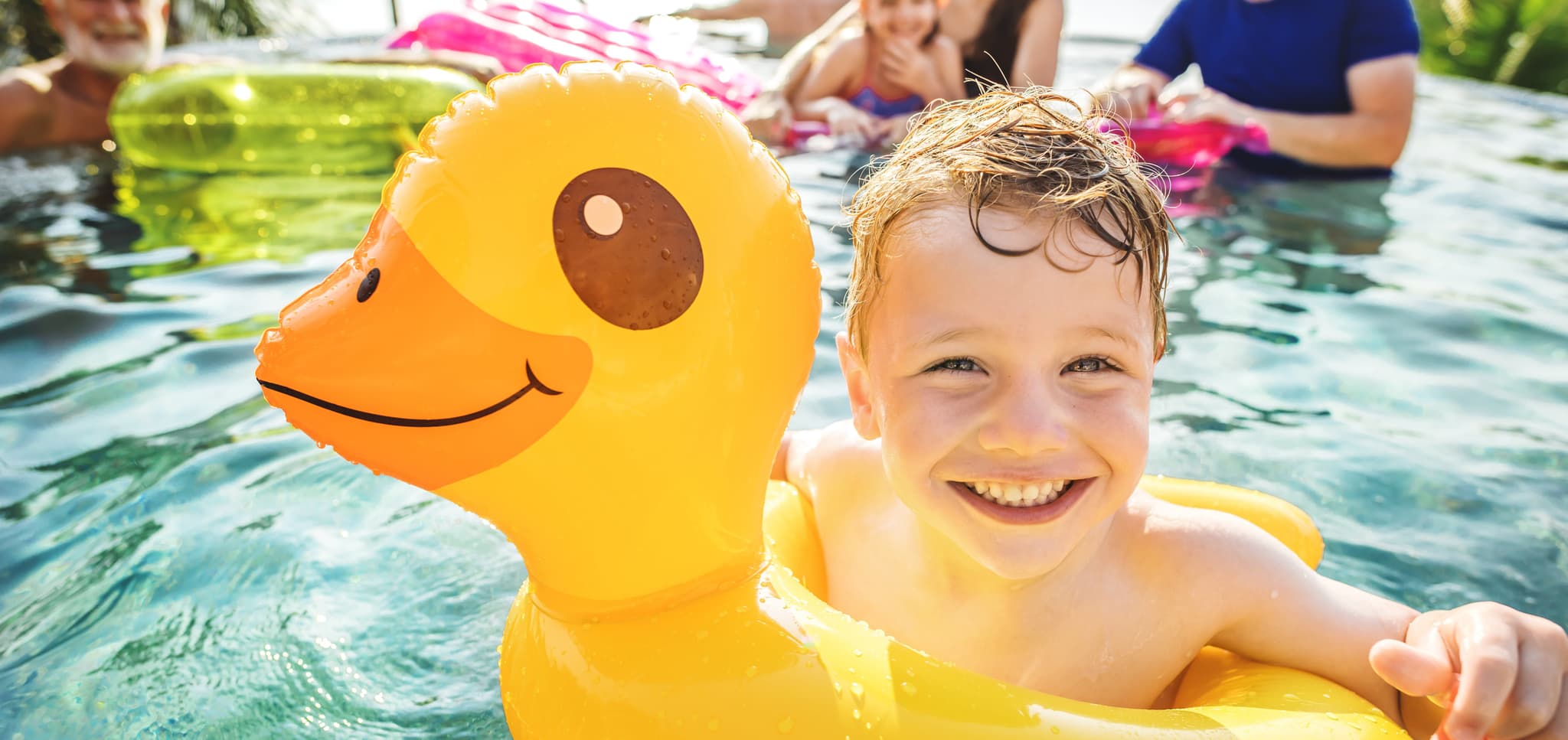 Picture of Boy swimming in a pool with family