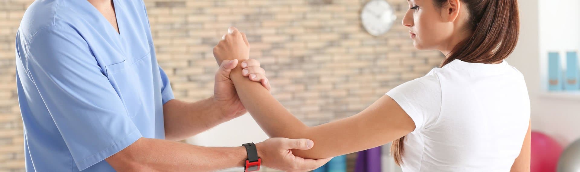 doctor helping woman with hand, wrist, elbow therapy