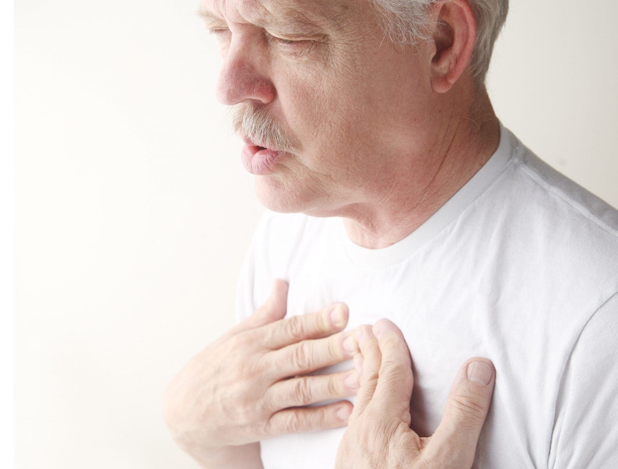 man exhales with hands on chest