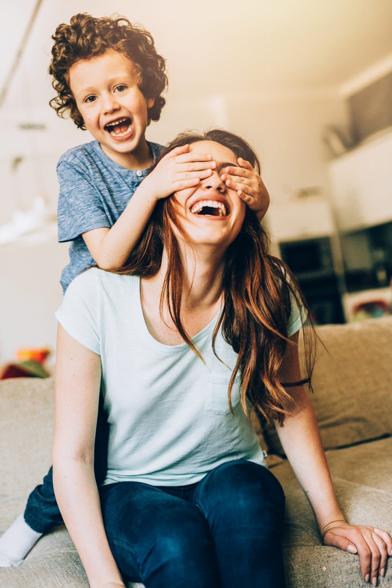 Mother and son playing in a living room.