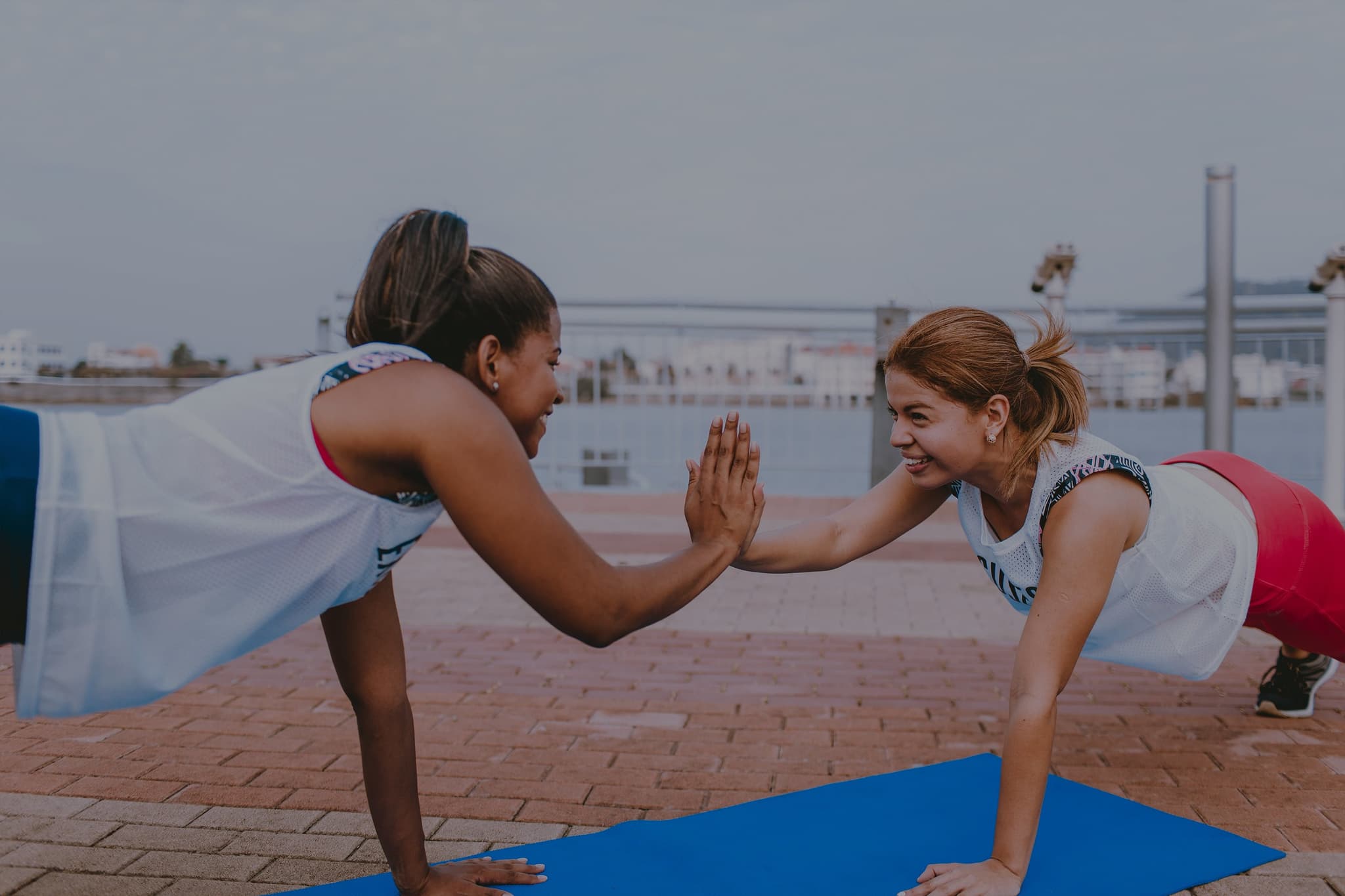 Picture of woman doing plank exercise together high fiving