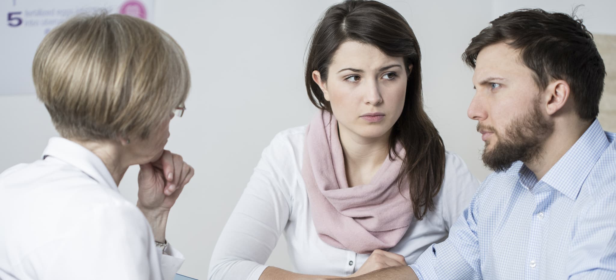 Picture of Young worried couple paying to experienced doctor for visit