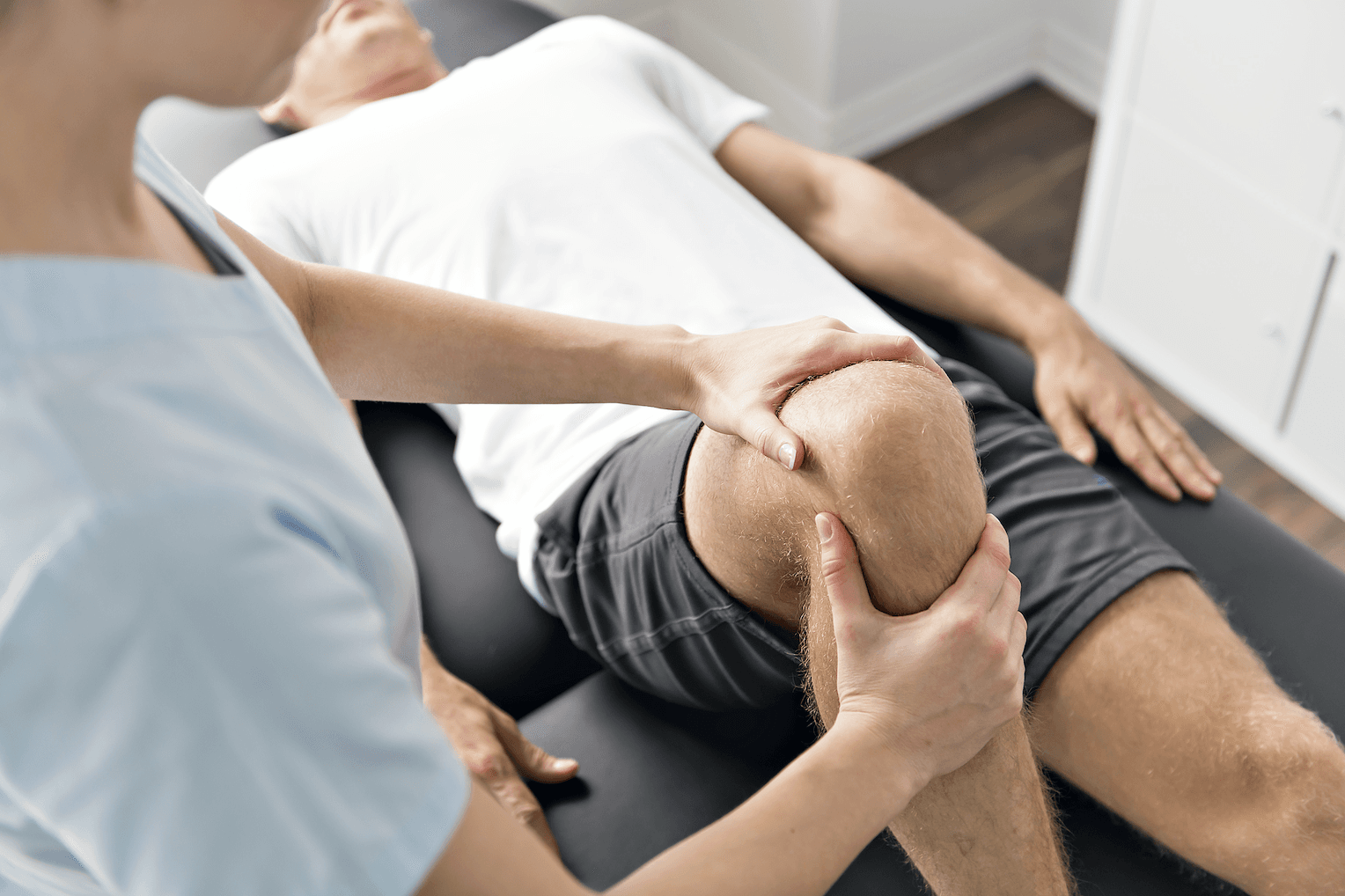 man with hurt knee being examined by doctor