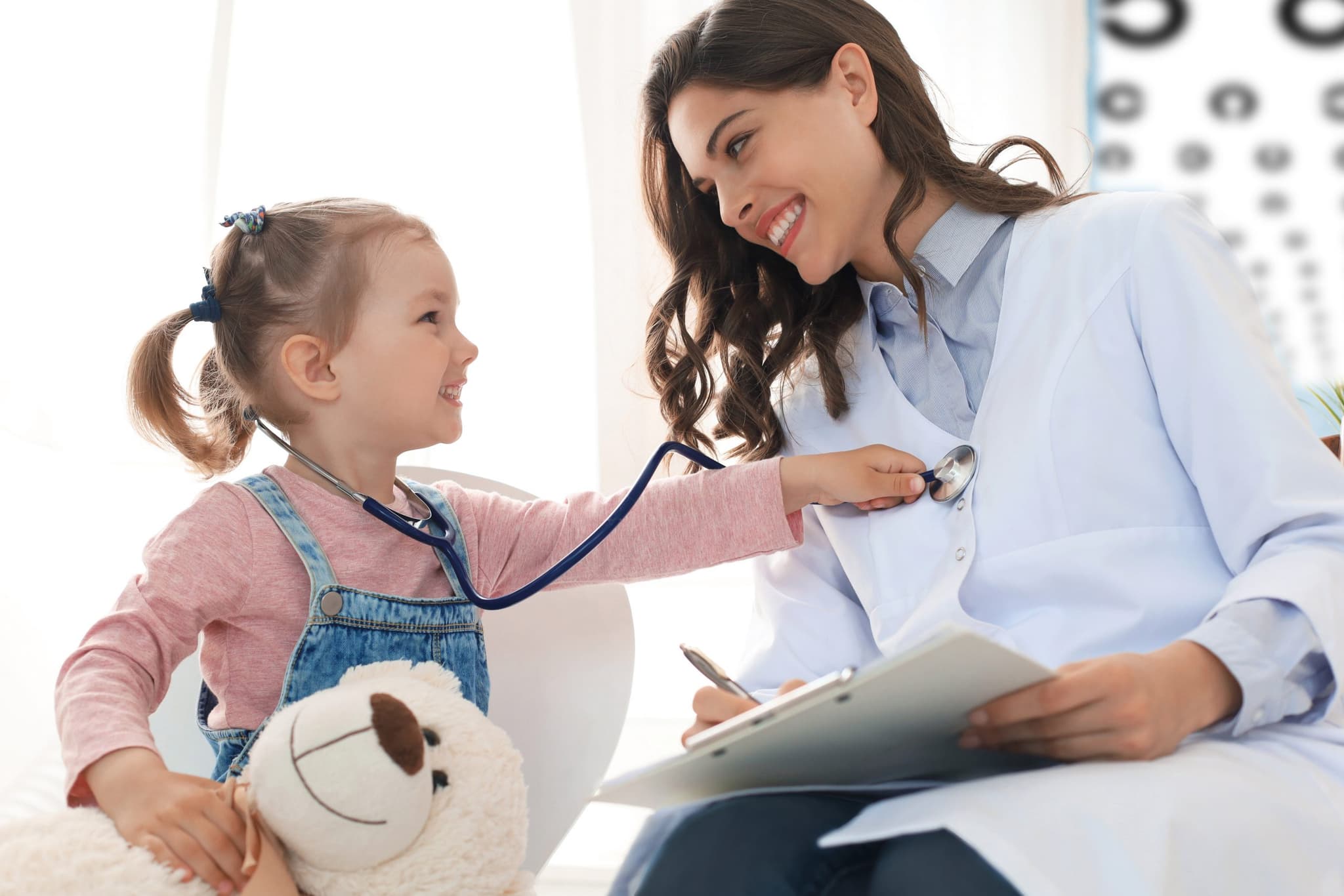 Image of Little girl at the doctor for a checkup. Child auscultate the heartbeat of the doctor.