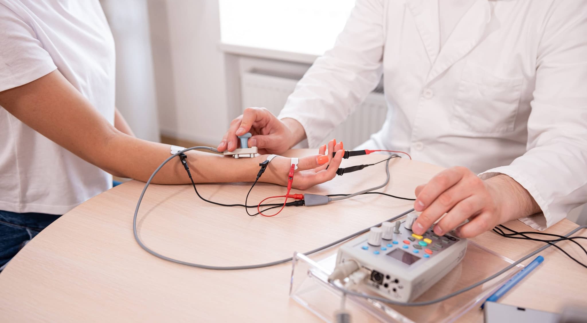 Image of a doctor performing a test on a patients arm to diagnose muscular issues. Discover how expert electrodiagnostic services can benefit your overall health by finding accurate and useful information. Call today!