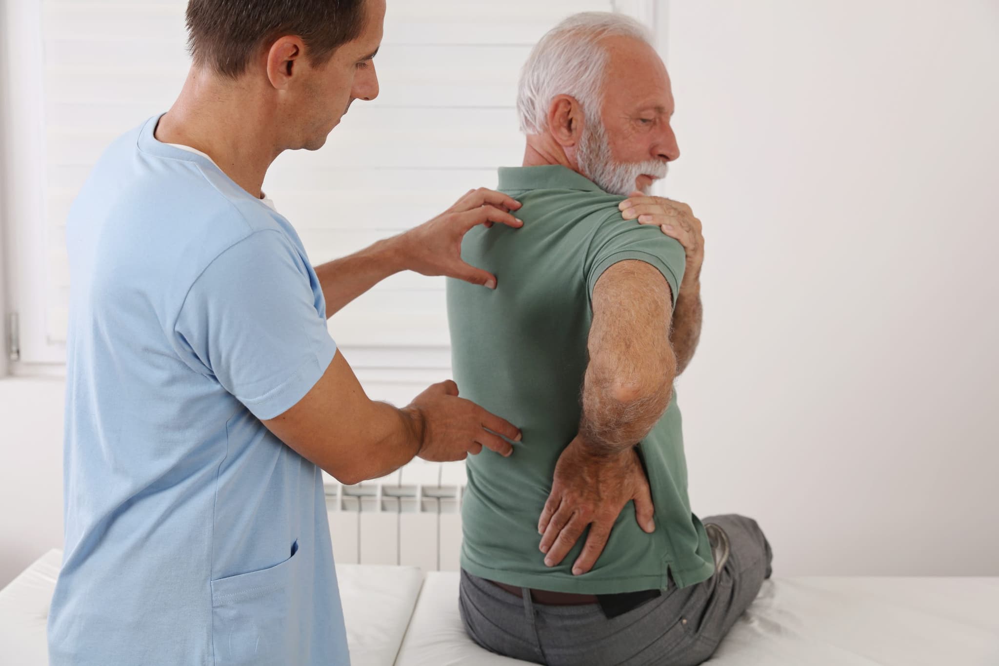 Picture of Senior man with back pain. Spine physical therapist and paient. chiropractic pain relief therapy. Age related backache