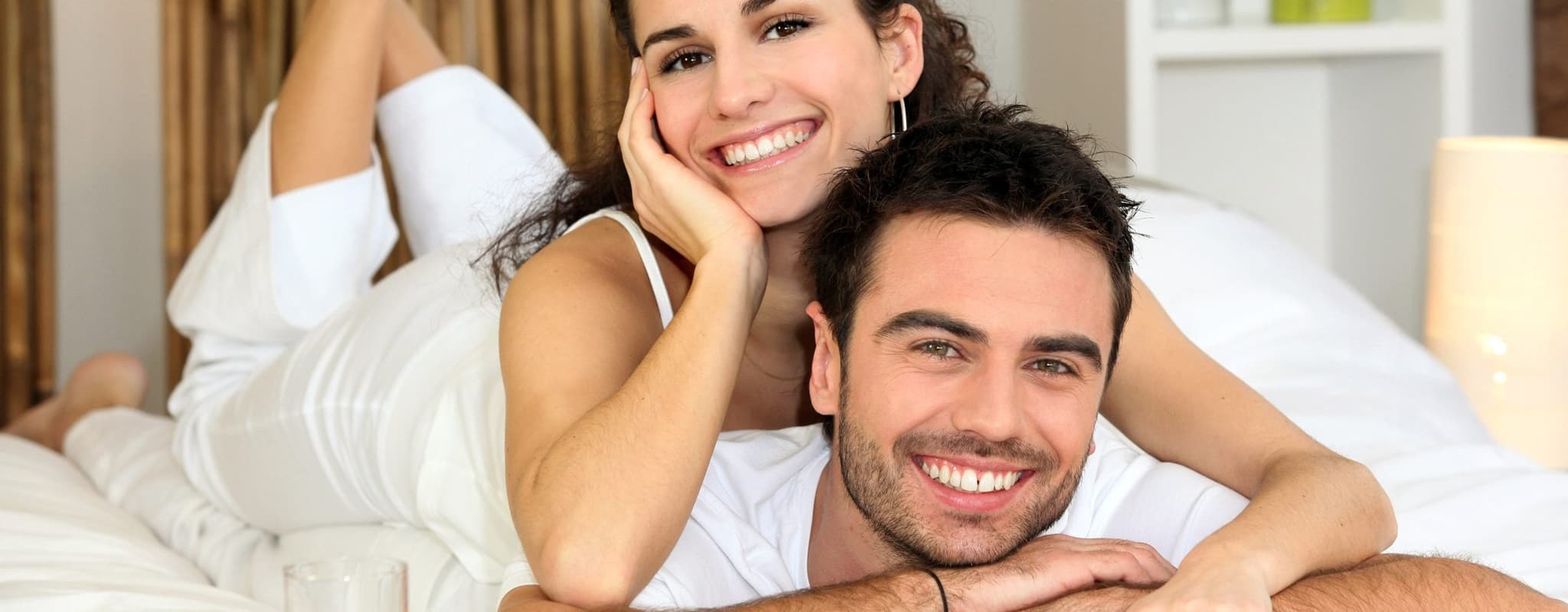 happy couple smiling on bed