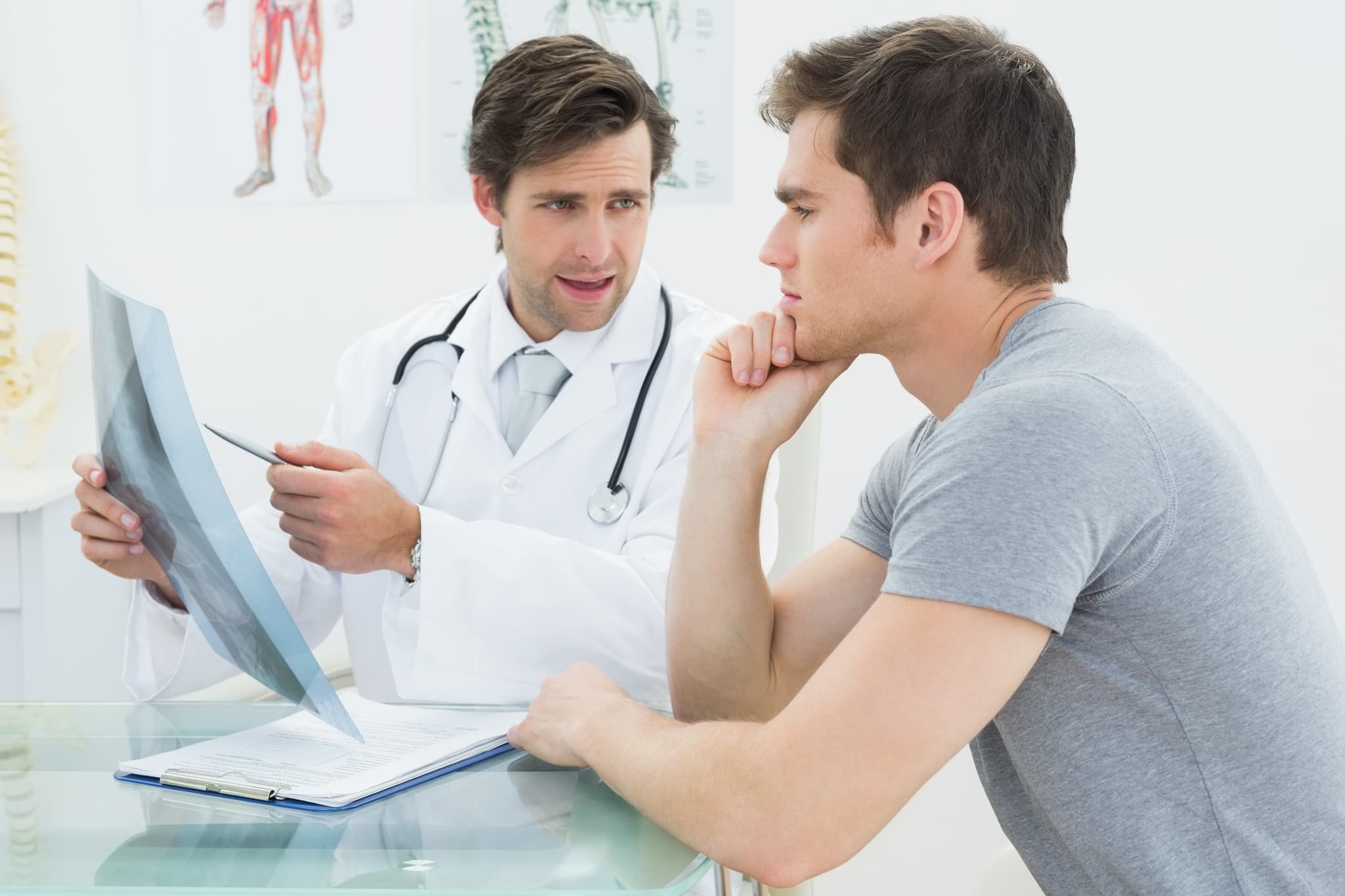 Male doctor explaining spine x-ray to patient in the medical office