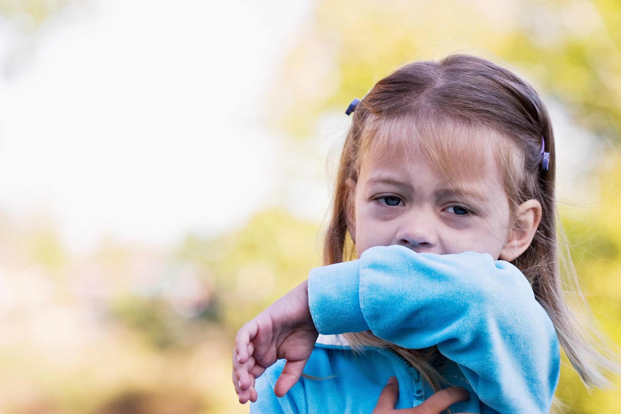 Picture of Little girl coughing or sneezing into her elbow.