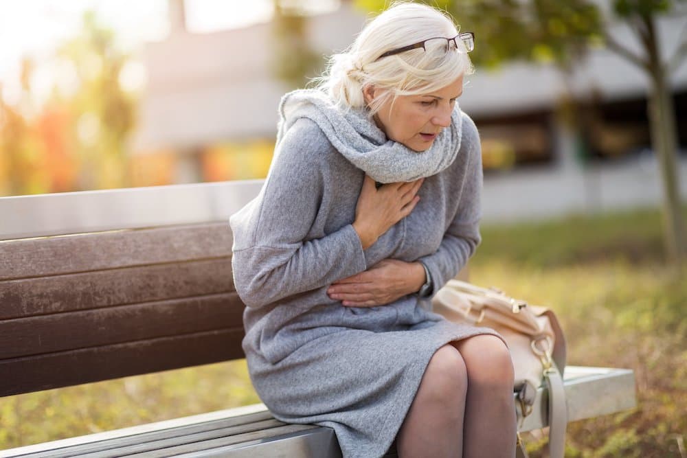 older woman clutching heart