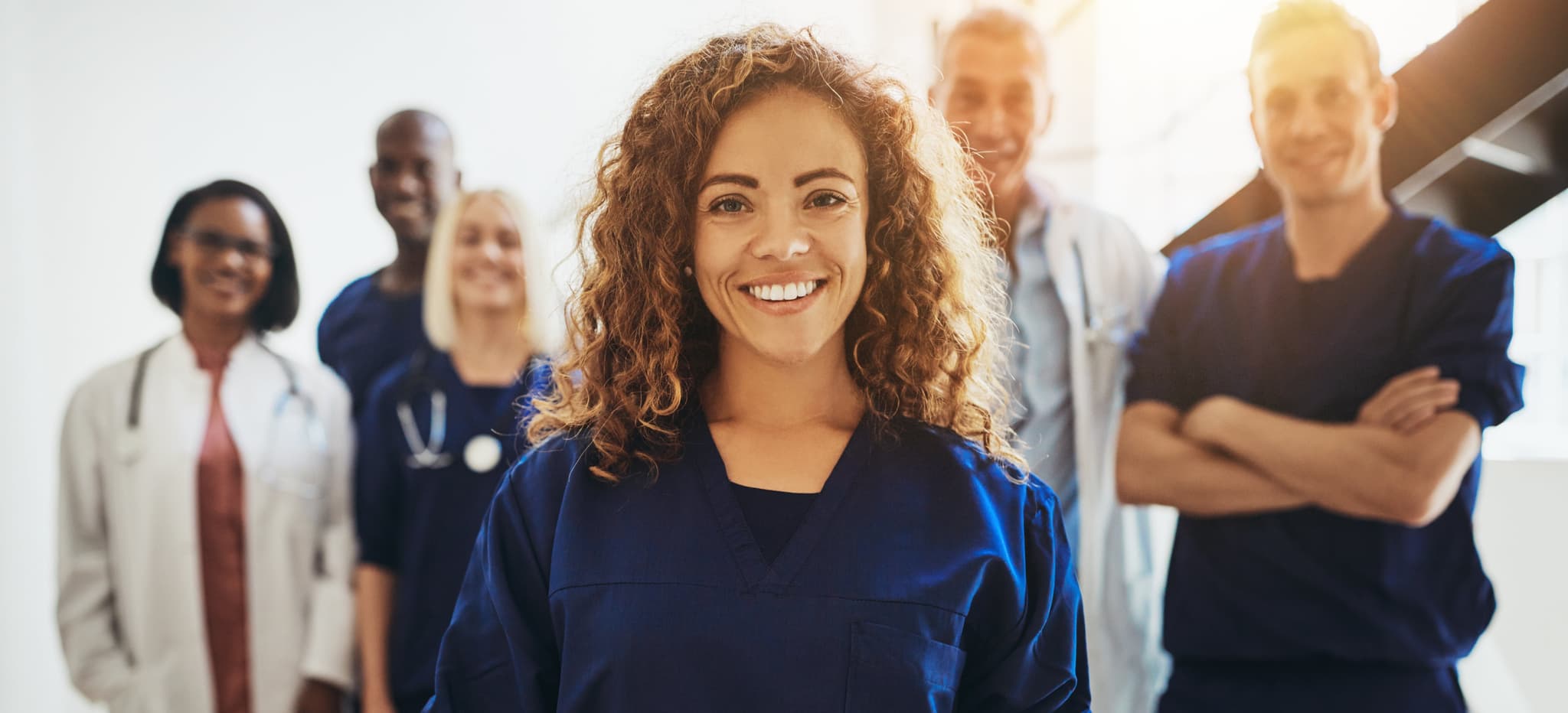 Smiling female doctor standing with medical colleagues in a hospital