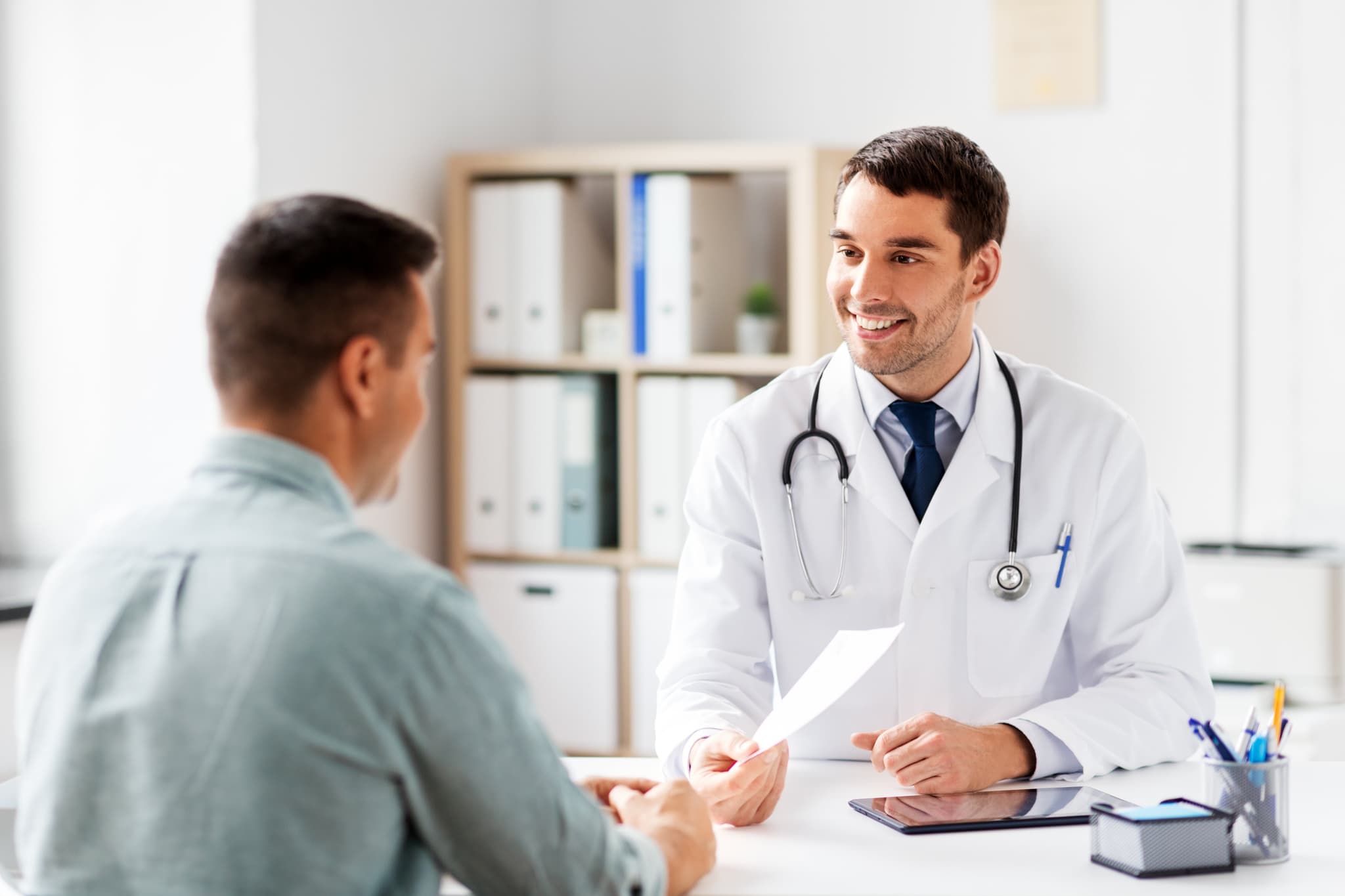 doctor giving prescription to patient at hospital