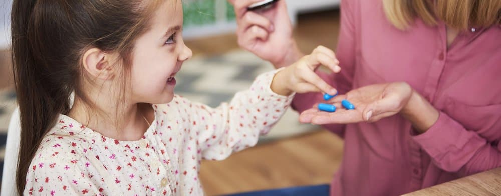 Picture of Young mum giving her little daughter the medicine