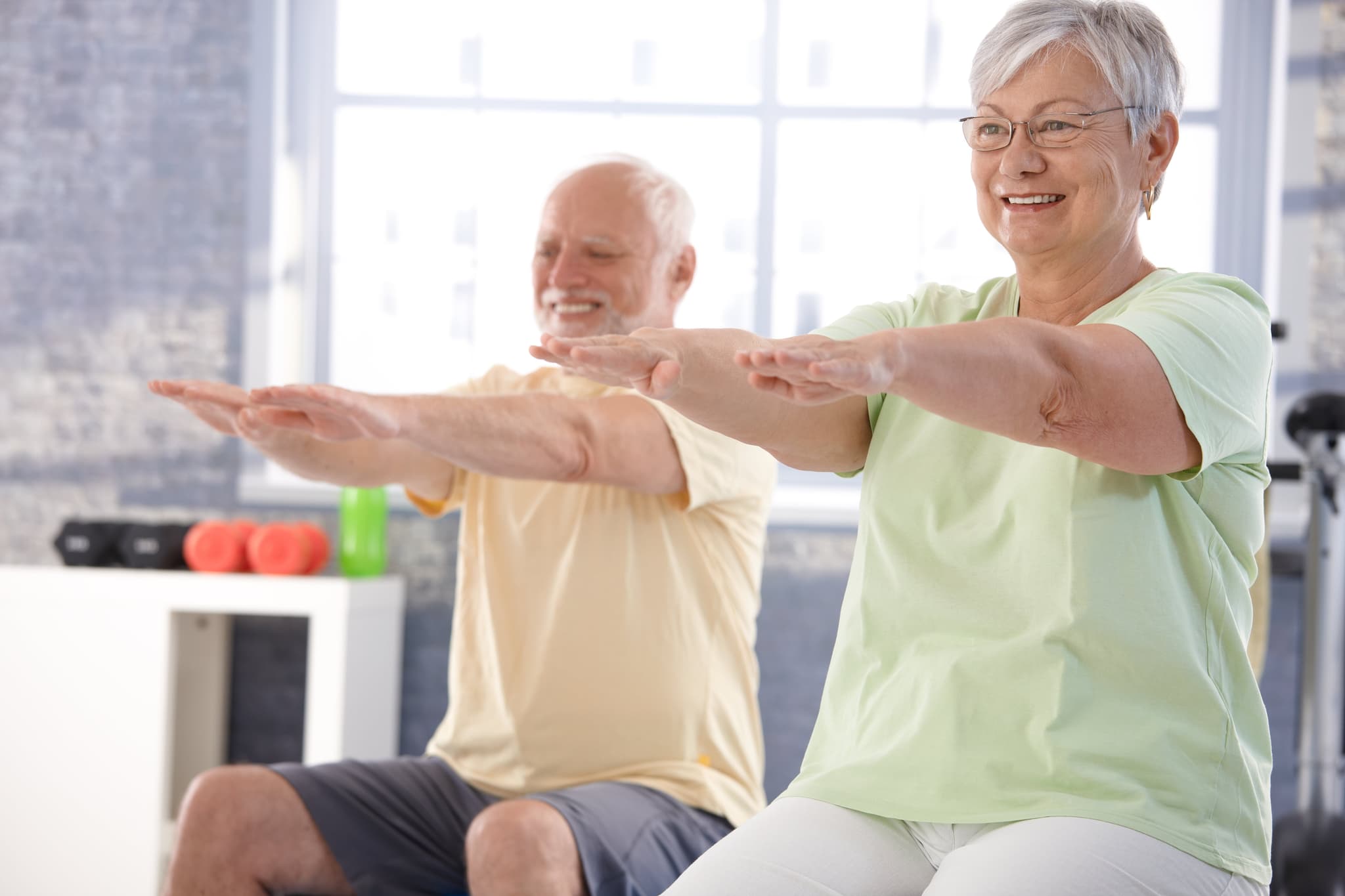 Picture of Mature people exercising happily in the gym.