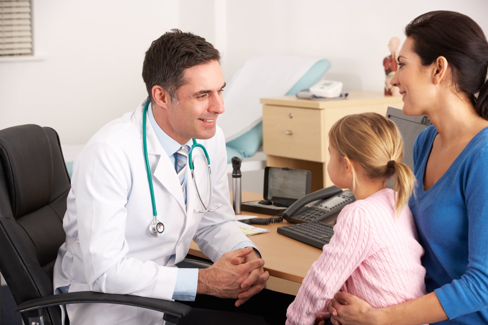 Doctor talking to young child and mother