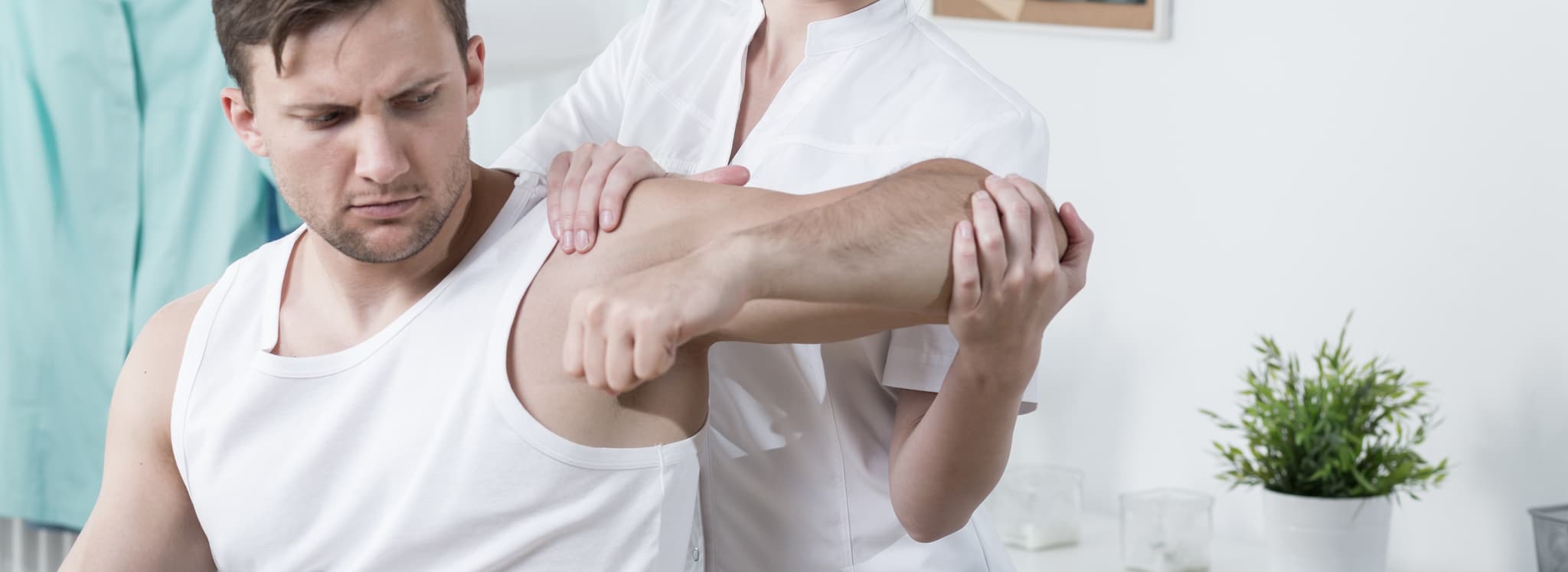 Young man is rehabilitated by female physiotherapist