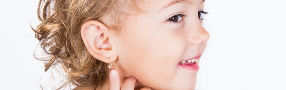 child showing ear piercing