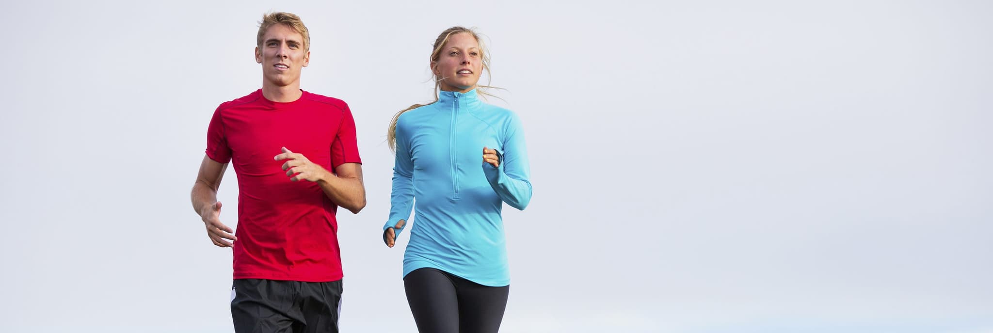 fit couple running on cloudy day
