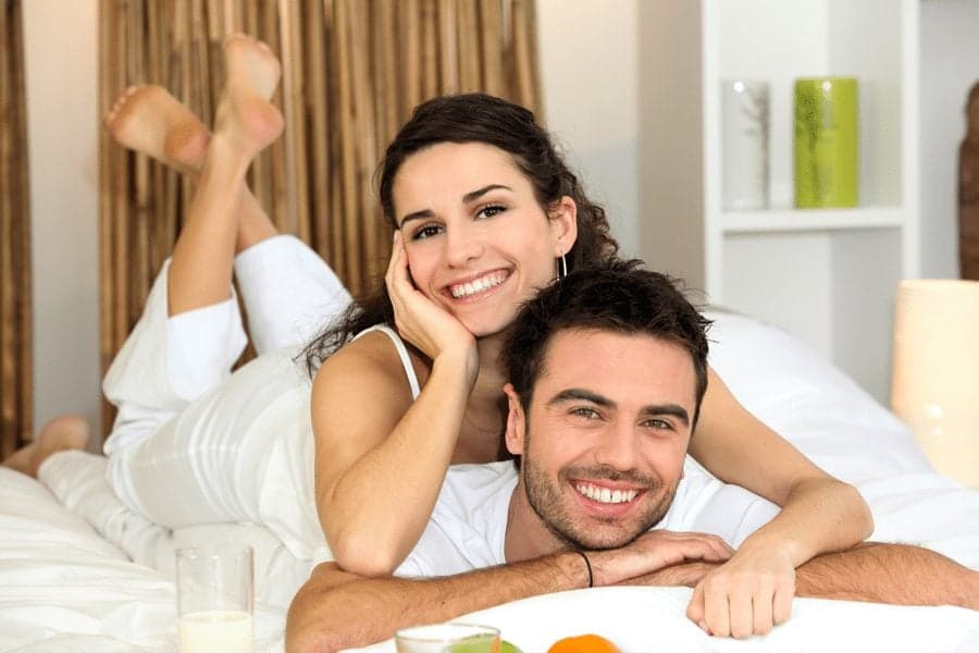 Picture of happy couple smiling on bed