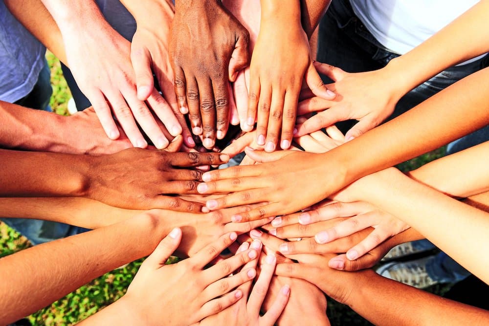 Picture of many hands together: group of people joining hands