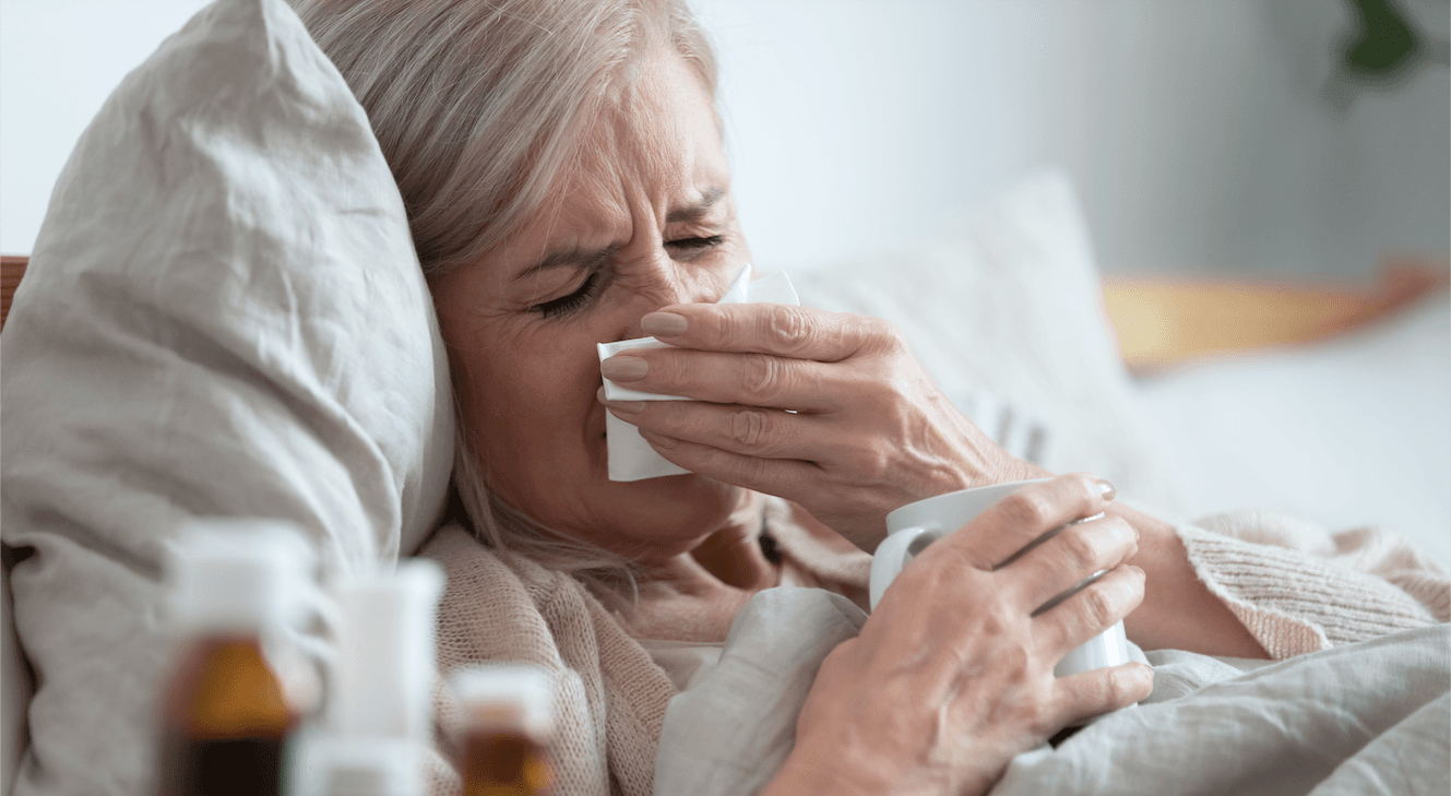 elderly woman blowing her nose
