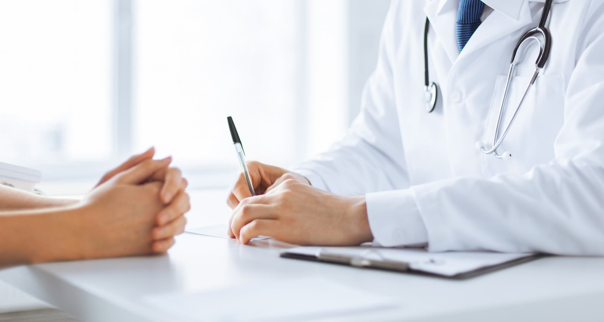 Picture of doctor writing while explaining things to patient