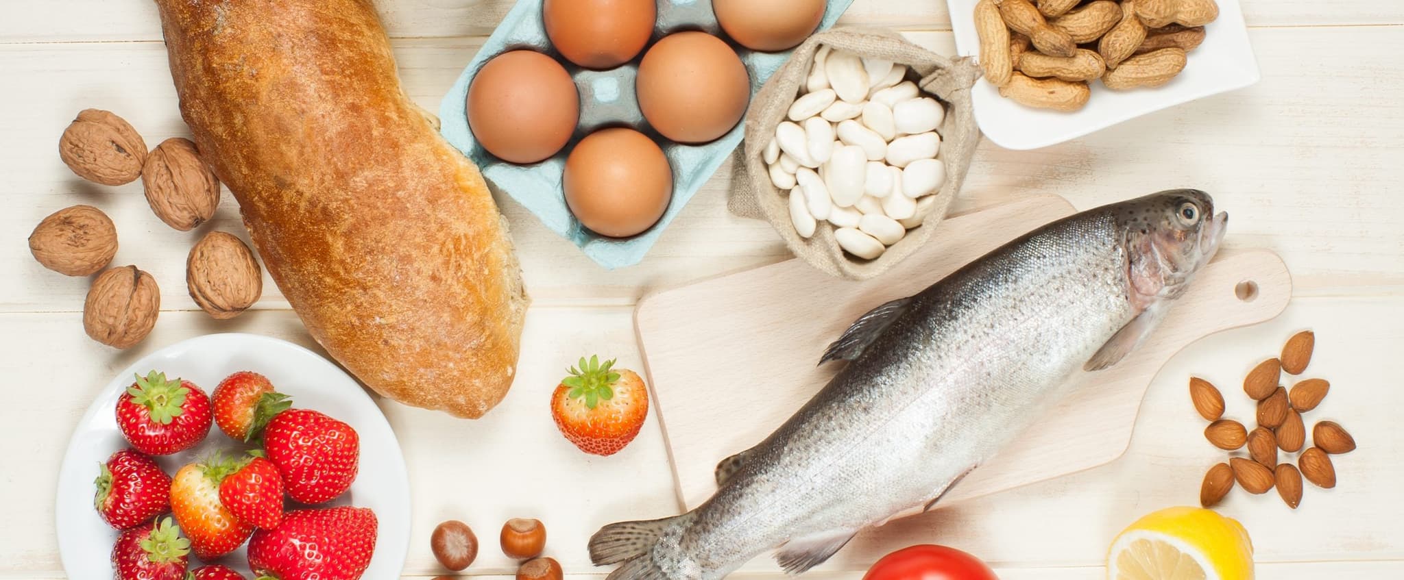 various food on a table - fish, bread, eggs, nuts, fruit, etc.