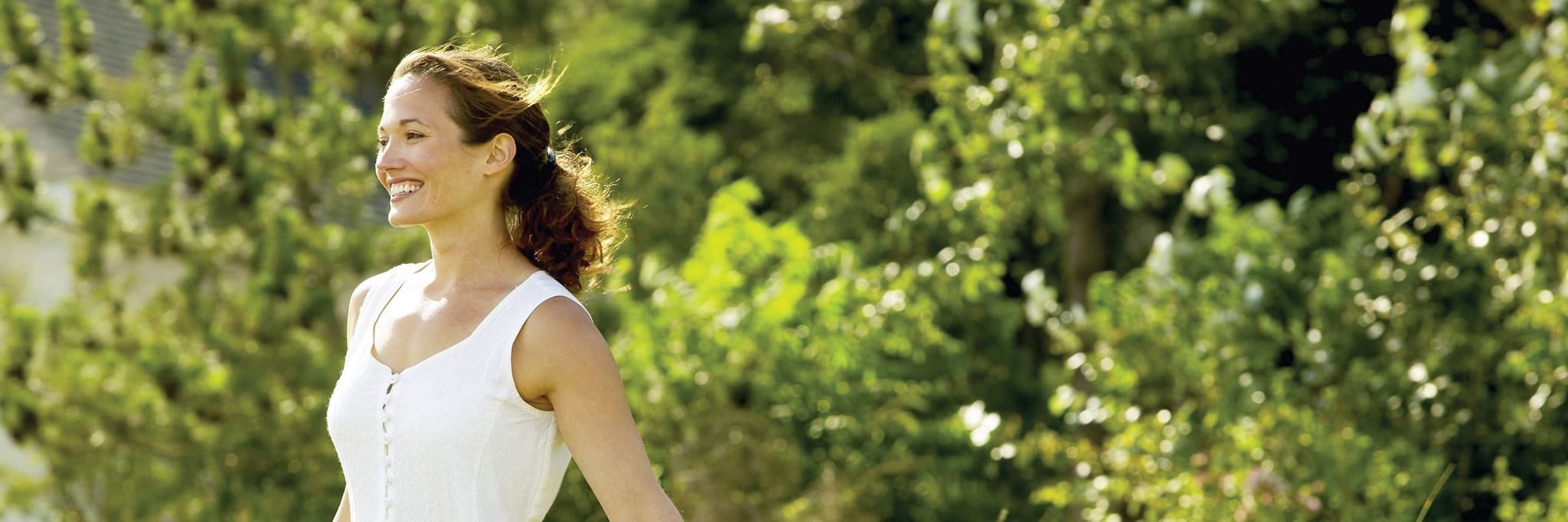 Picture of happy woman walking through grassy field