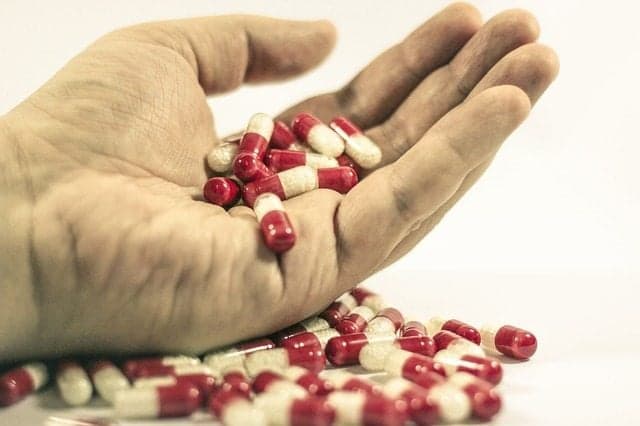 Picture of person holding Medication pills - pills on table