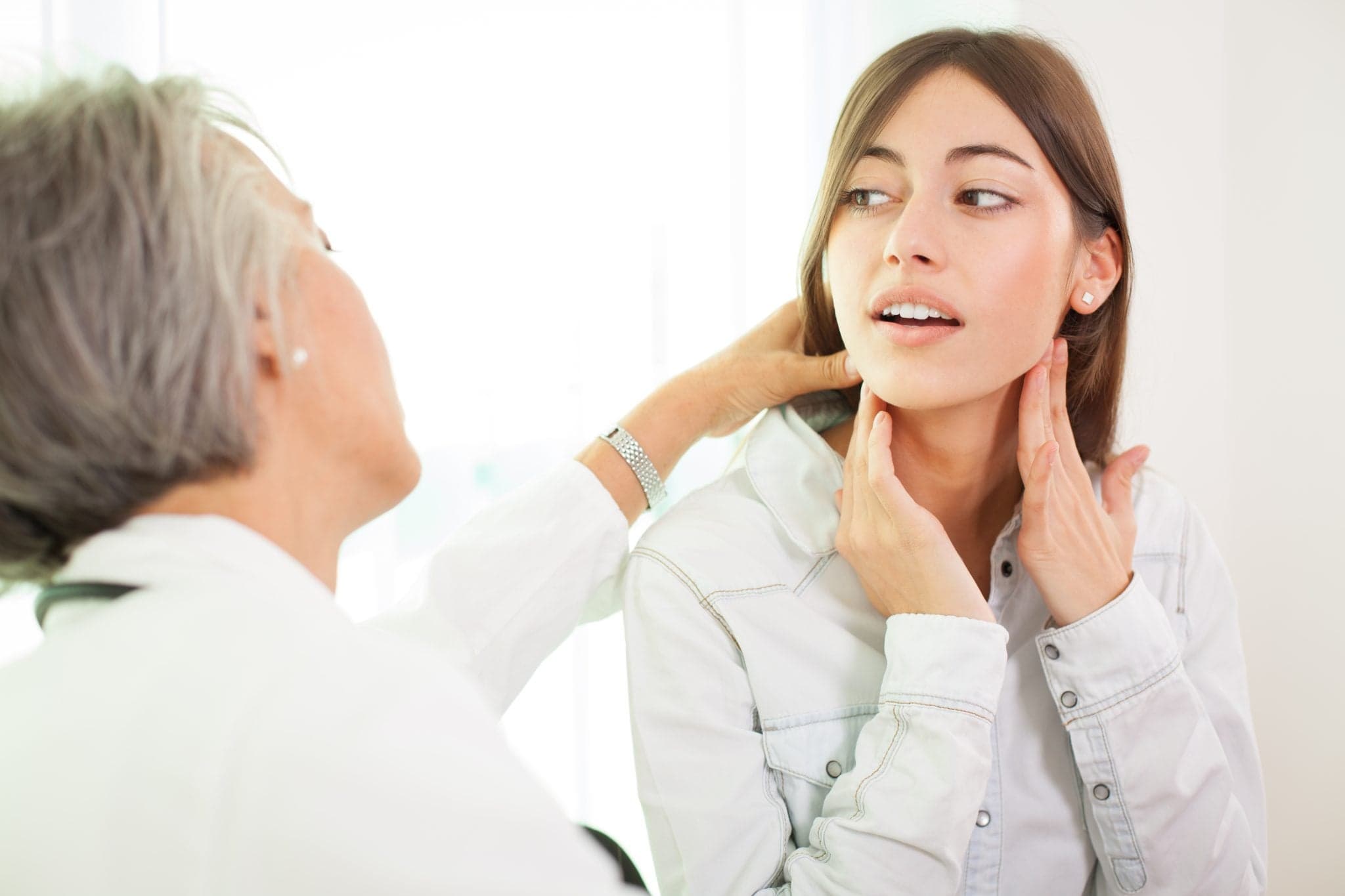 Picture of woman having throat examined by doctor