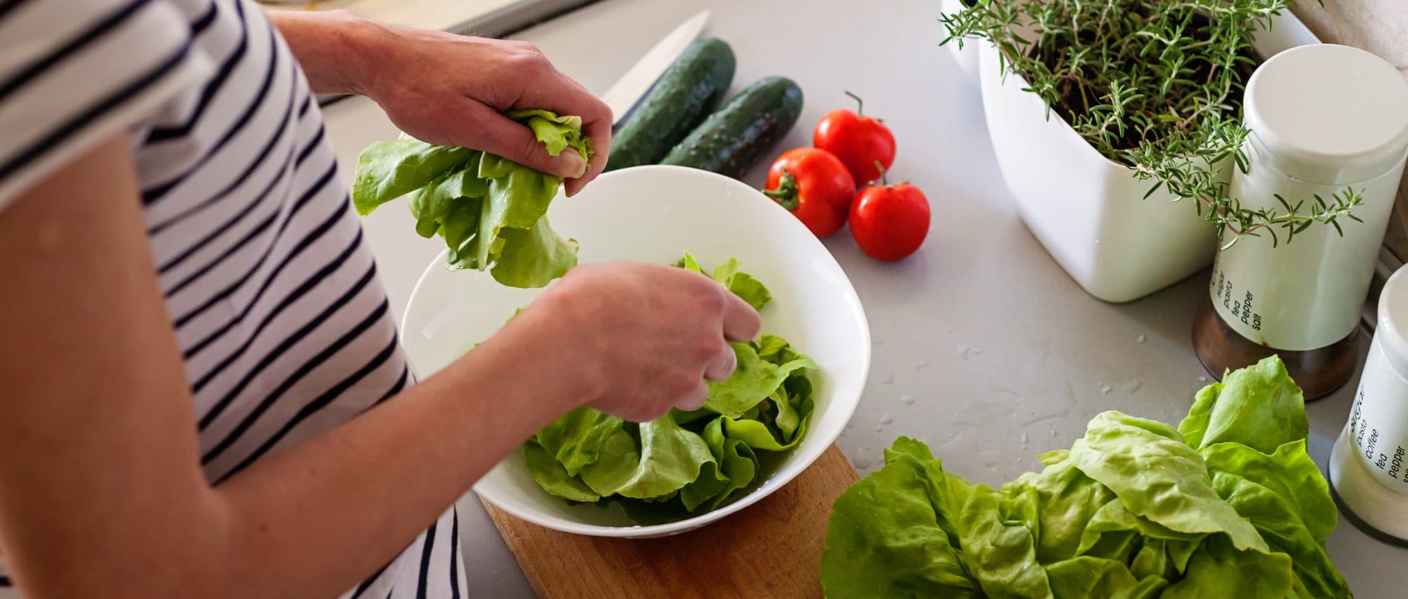 Picture of young woman making vegetable salad