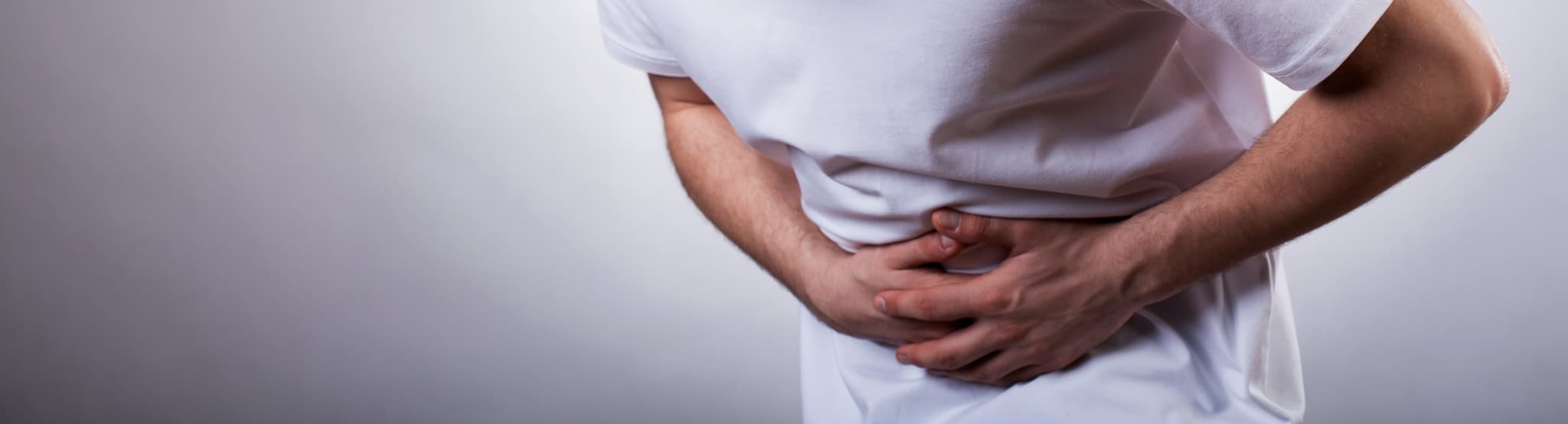 Picture of Young man with severe stomachache holding his stomach