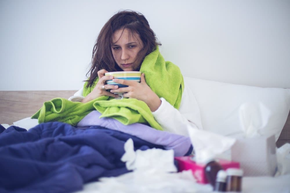 Eating chicken noodle soup in bed while sick