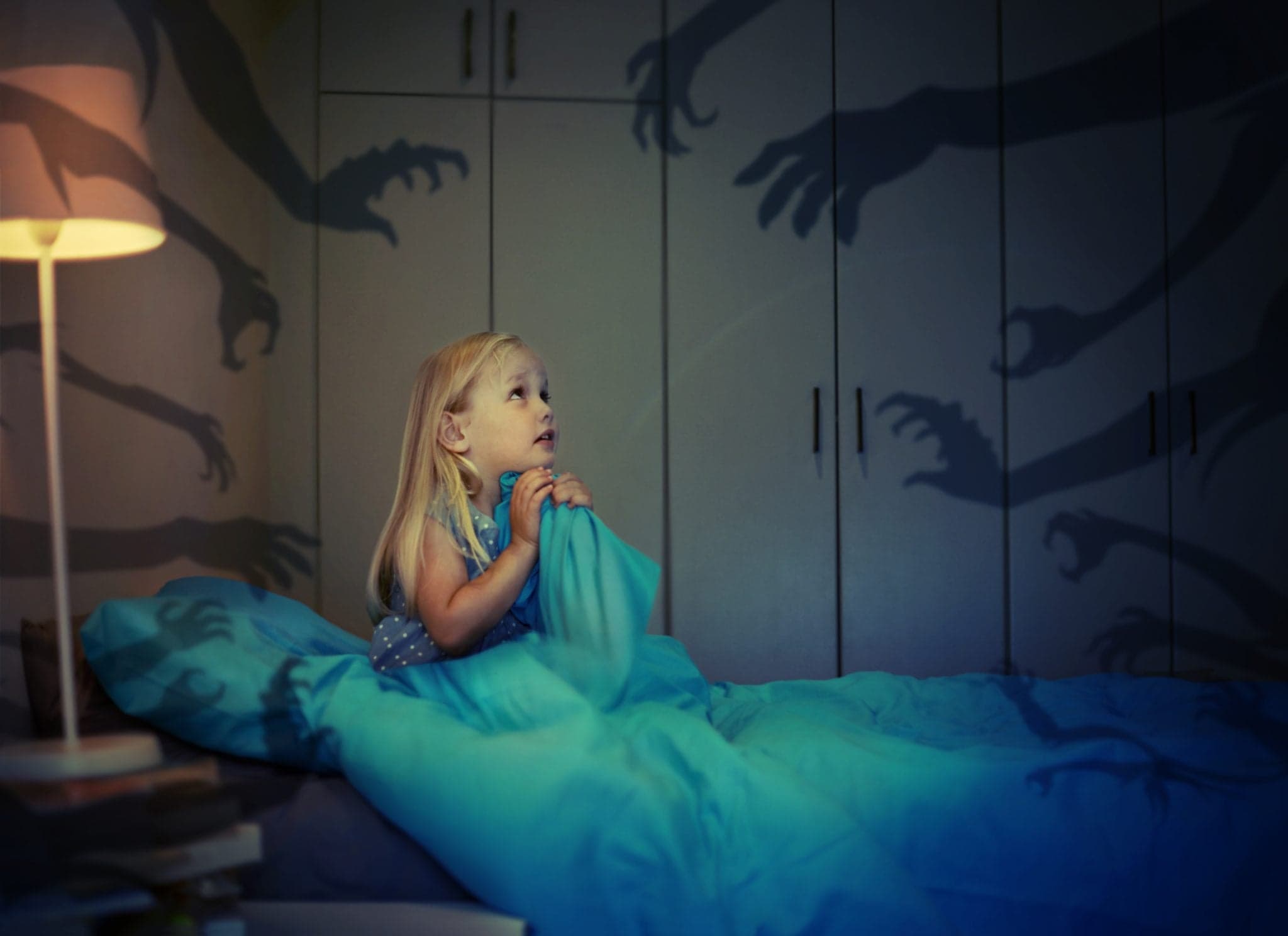 little girl in bed scared of shadow hands on walls - nightmare