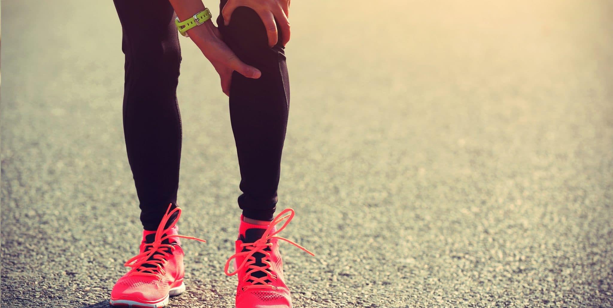 Picture of woman runner hold her injured leg on road