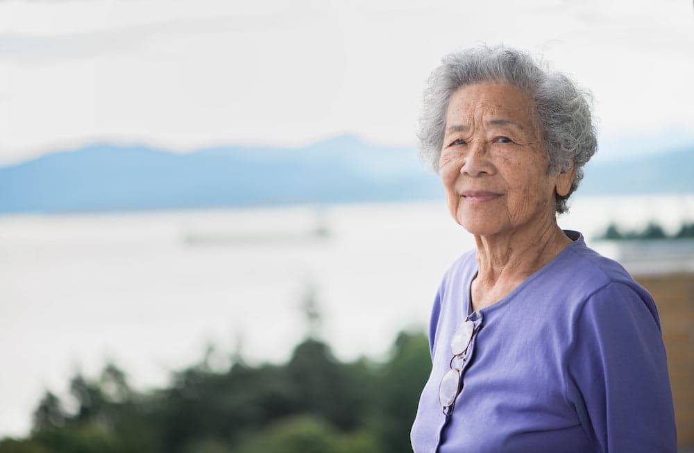 Picture of Portrait of a fit, Chinese woman in her 80s, living independently and looking at the view from her apartment overlooking English Bay in Vancouver, British Columbia, Canada.