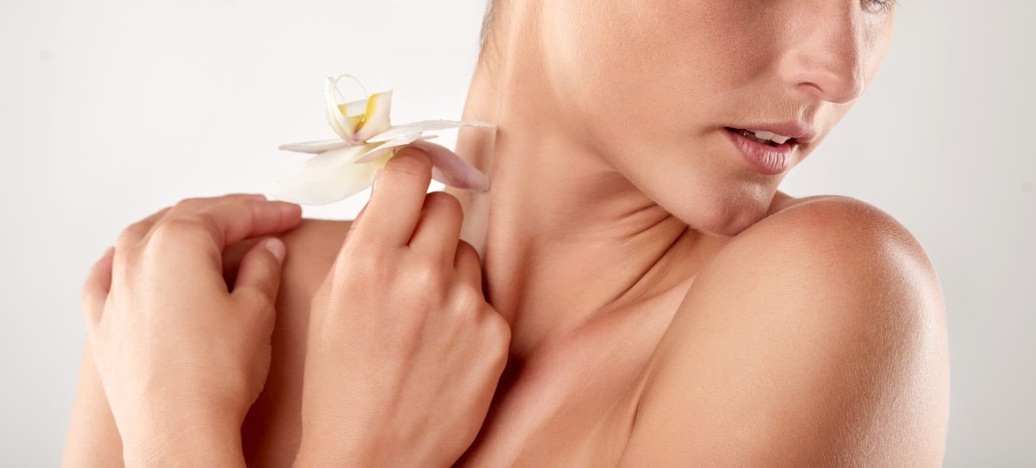 Picture of Closeup studio shot of a beautiful young woman holding an orchid