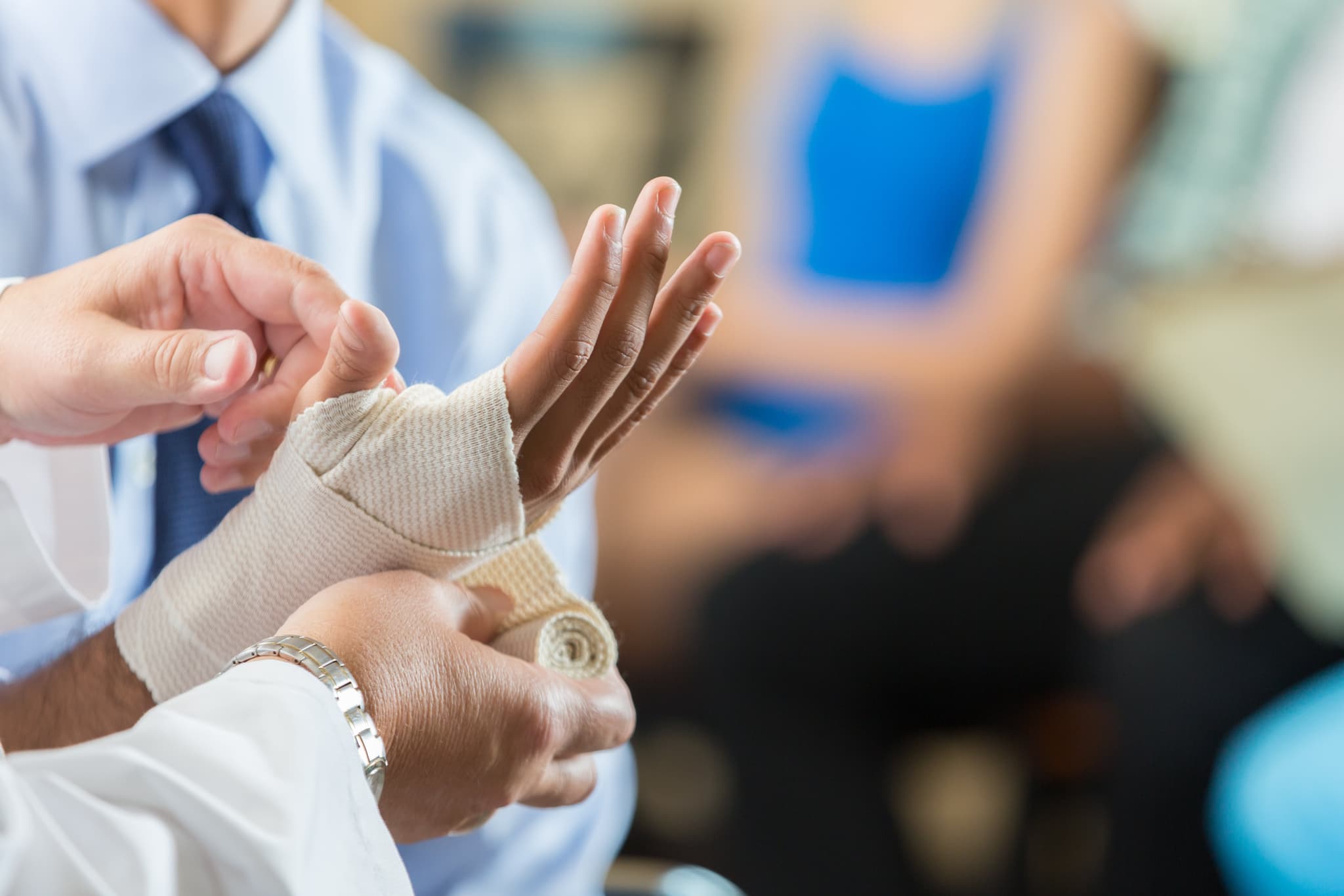 Picture of Patient having wrist bandaged by nurse in hospital triage center