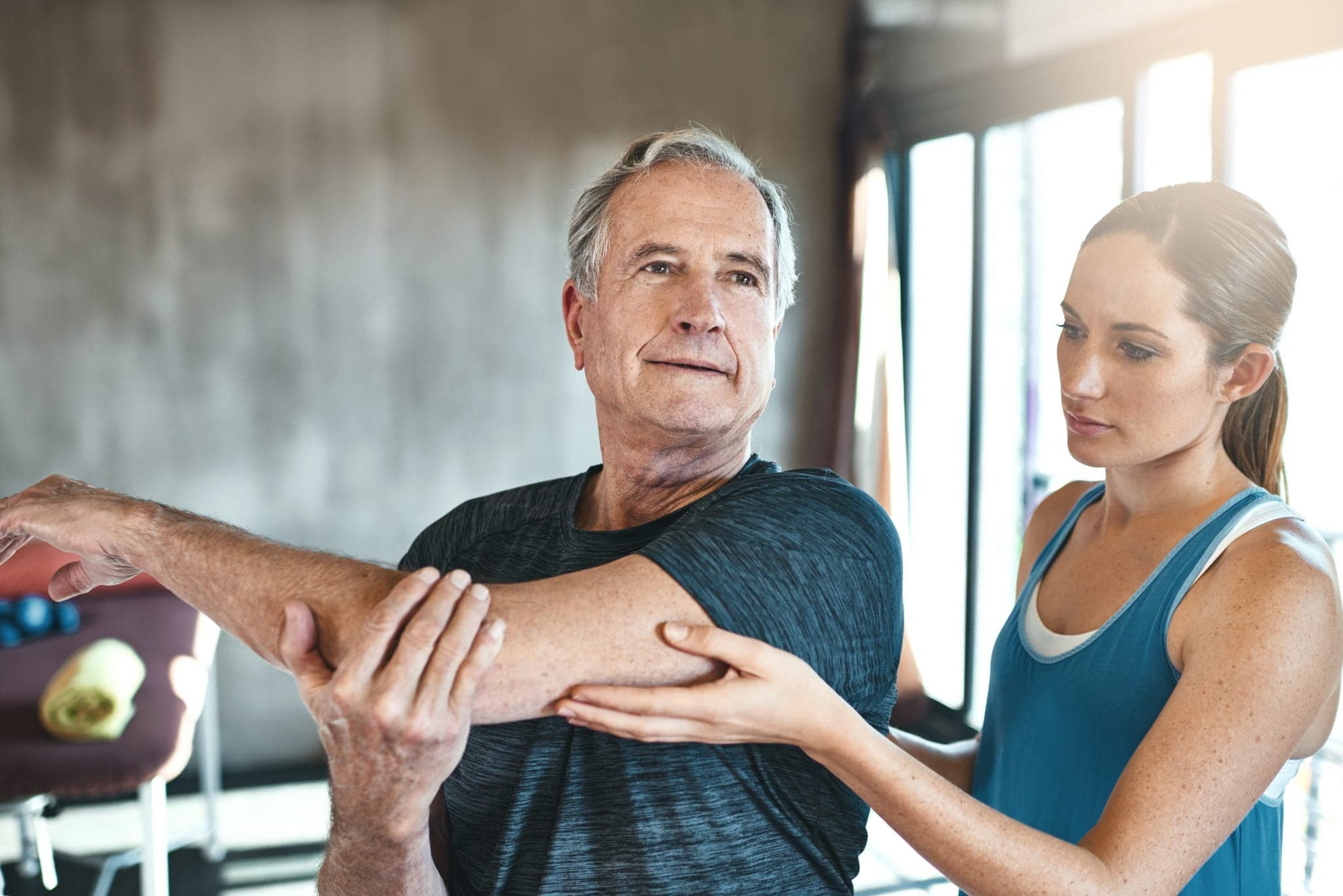 Shot of a senior man working out with the help of an instructor