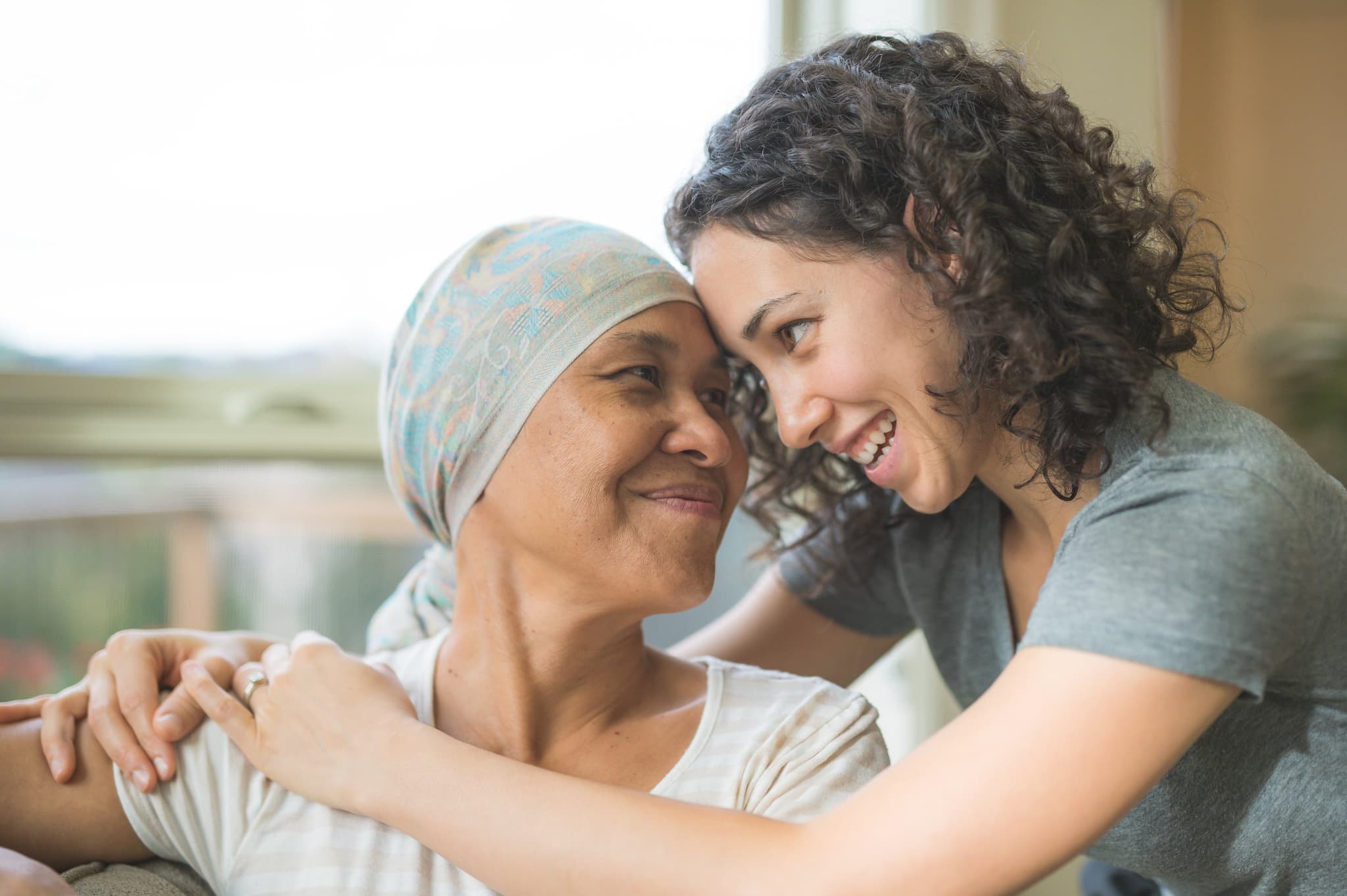 Picture of Ethnic adult female cancer patient hugging her daughter